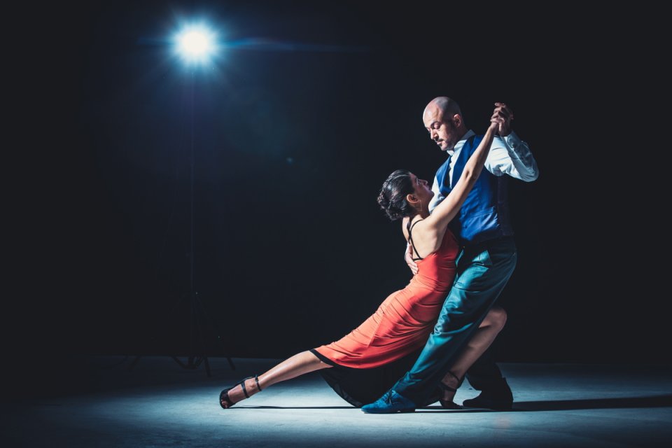 Frau und Mann tanzen unter licht